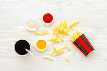 Patatoes french fries in red paper box with different sauces
