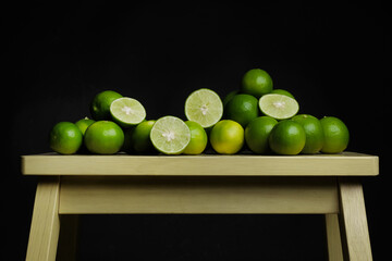 Green limes on the wooden table - 448603900
