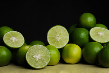 Green limes on the wooden table - 448603910