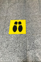Yellow social distance sign at the airport