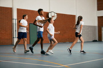 Multi-ethnic group of school kids running during physical education class.