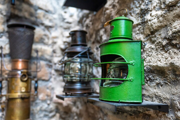 Old ship green lantern hanging on the wall. Vintage lights.