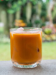 ice tea or ice thai tea in glass , fresh dessert in coffee cafe with nature background