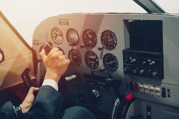 Pilot hand or private flight captain control airplane with many aircraft gauge in cockpit dashboard.