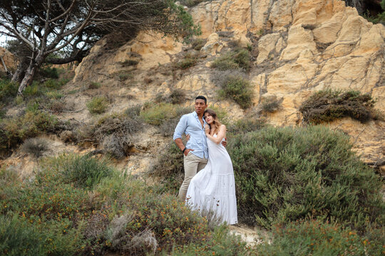 Loving multiracial couple of newlyweds hugging in woods