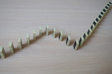 domino dice standing vertically in a zigzag line on a light wooden surface