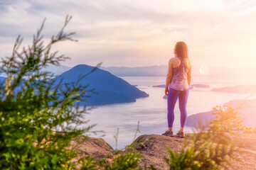 Adventurous Caucasian Adult Woman hiking on top of a mountain during a colorful sunny summer...
