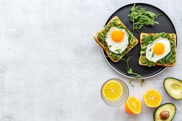 Open sandwich with eggs and avocado on plate. Overhead view