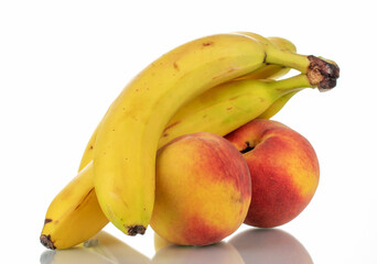 Several ripe bananas and peaches, close-up, isolated on white.