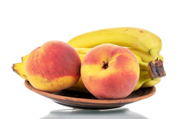 Several ripe bananas and two peaches, close-up, isolated on white.