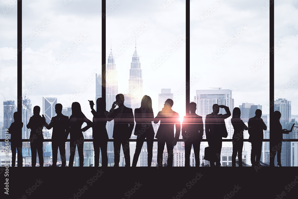 Poster Crowd of backlit businesspeople standing in abstract interior with city view and mock up place on panoramic windows. Teamwork and communication concept.