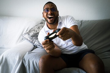 A black man person  plays euphoric with his console