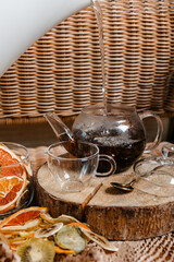 Organic dried fruits. Homemade dehydrated fruit chips in a glass form. The concept of healthy eating. dried apples, orange, grapefruit, kiwi, banana top view. A glass teapot with tea on a log.