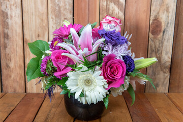 Beautiful bouquet of arranged stargazers, roses, mums, and white daisys displayed in a lovely vase