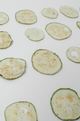 Organic dried zucchini on a white background. Vegetable chips with Provencal herbs. Snacks from dried fruits. The concept of healthy eating.