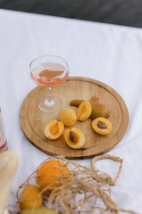 Picnic. fruit and a glass saucer with pink wine on a white sheet. The concept of a romantic holiday. a cozy picnic in nature.