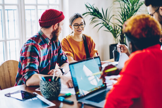 Skilled male and female freelancers have brainstorming meeting for discussing high tech and internet connection for web projecting via laptop device, young IT professionals collaborating at desktop