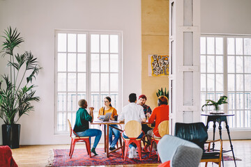 Diverse team of creative developers collaborating on startup project during brainstorming meeting...