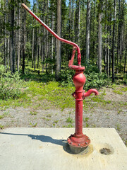 Old fashioned red water pump in Kananaskis national park near Banff Alberta Canada.