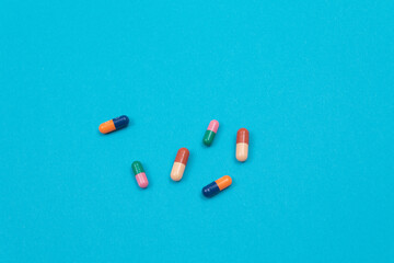 Global Pharmaceutical Industry and Medicinal Products - Colored Pills or Capsules Scattered on Blue Background