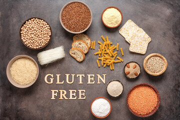 Selection of gluten free food on a brown grunge background. A variety of grains, flours, pasta, and...