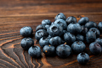 Blueberry on dark wooden background.