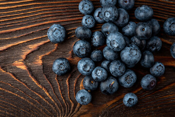 Blueberry on dark wooden background.