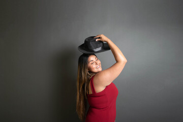 fashion and elegant overweight latina woman with red dress and fedora hat