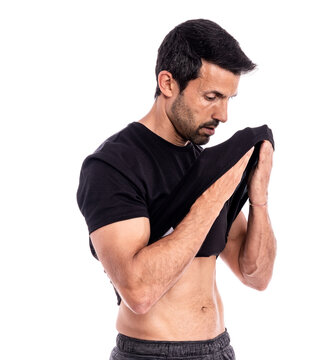 European man, caucasian, an athlete, wipes sweat from his forehead with a T-shirt. After a hard workout. Stress and fatigue. On a white background.