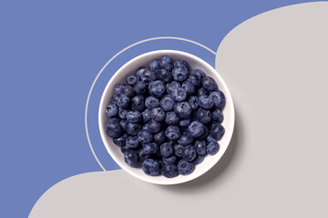 Creative food health diet concept photo of plate dish bowl with blueberry on grey background..