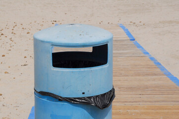 Blue bin on the beach in Spain