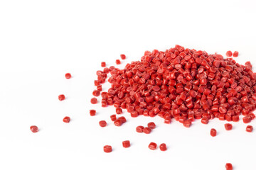 Red granules of polypropylene or polyamide on a white background. Plastics and polymers industry....