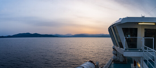 leve de soleil depuis bateau de transport touristique à l'approche d'une île. Vue depuis le dernier pont d'un paquebot de croisière