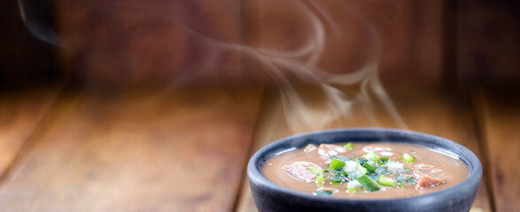 brazilian bean broth, in a clay bowl with heat smoke, hot brazilian food
