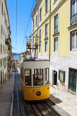 Fototapeta na wymiar Vintage tram in the city center of Lisbon in a beautiful summer day, Portugal. Traditional yellow tram on a street in Lisbon, Portugal.