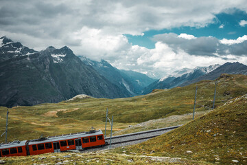 Railway in mountains and red train. Zermatt, Swiss Alps. Adventure in Switzerland, Europe.