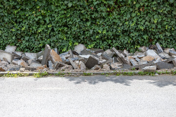 paving work to renew the walkway, destroyed old stones, hedge in the background