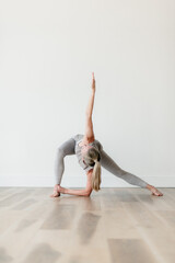 flexible athletic woman holding yoga pose in studio