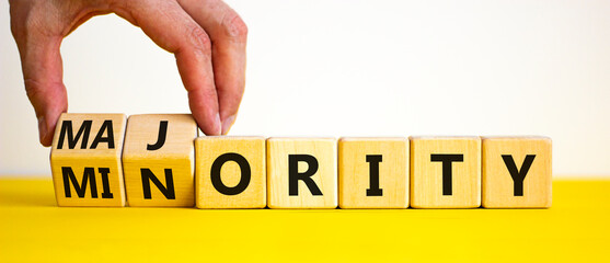 Minority or majority symbol. Businessman turns wooden cubes and changes the word 'minority' to 'majority'. Beautiful white background. Minority or majority and business concept. Copy space.