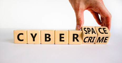 Cyber-space vs cybercrime symbol. Businessman turns wooden cubes, changes words cybercrime to cyber-space. Beautiful white background. Cyber-space vs cybercrime concept. Copy space.