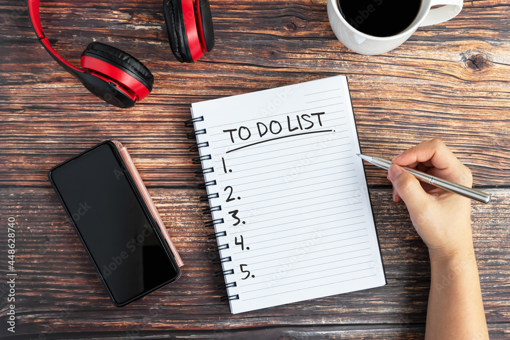 Wall mural hand writing to do list text on note pad on top of desk with smartphone and cup of coffee