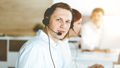 Businessman working at customer service office. Group of diverse operators at work in sunny call center