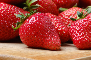 Strawberries on wooden table. Pile of strawberries on a blurred background.