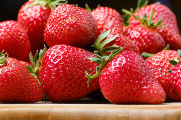 Strawberries on wooden table. Pile of strawberries on a blurred background.
