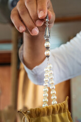 close up view to pearl necklace in hand of salesman on pear factory in UAE