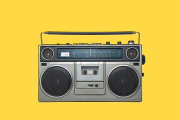 RADIO CASSETTE PLAYER ON YELLOW BACKGROUND. URBAN MUSIC FASHION FROM THE EIGHTIES.