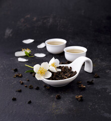 Obraz na płótnie Canvas Green tea with Jasmine flowers on a black background, Herbal medicine.