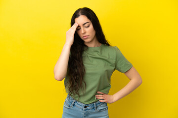 Young caucasian woman isolated on yellow background with headache