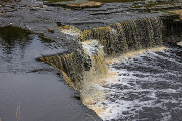 Top view-the cascade of the Tosnensky waterfall in the Leningrad region, Russia, close-up on a cloudy summer day and a space for copying