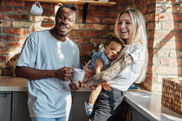 Happy multiethnic family together on kitchen in sunlight